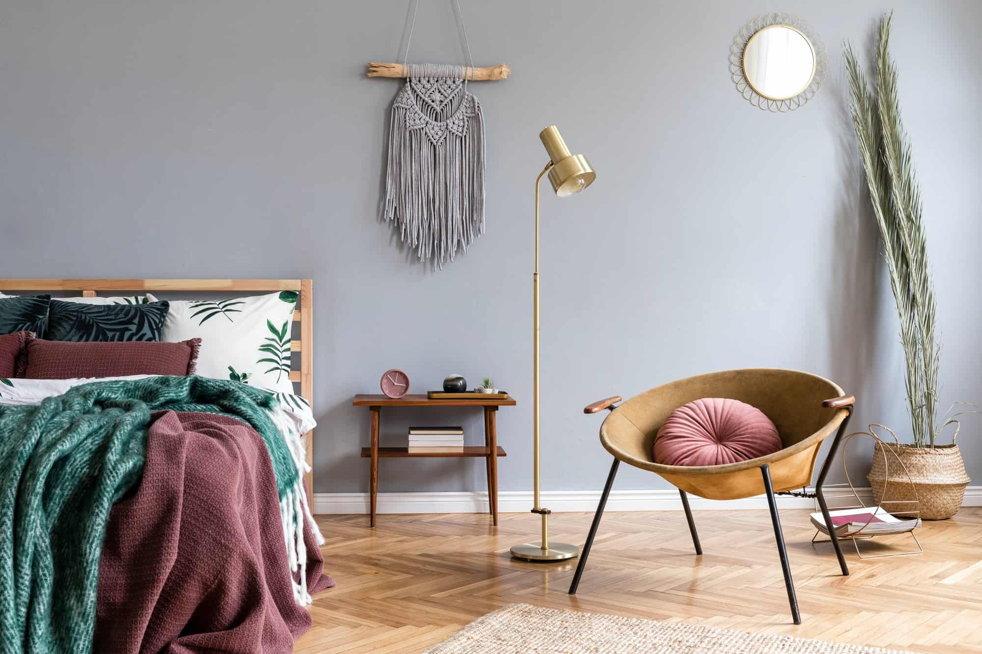 Stylish boho interior of bedroom with design furnitures.